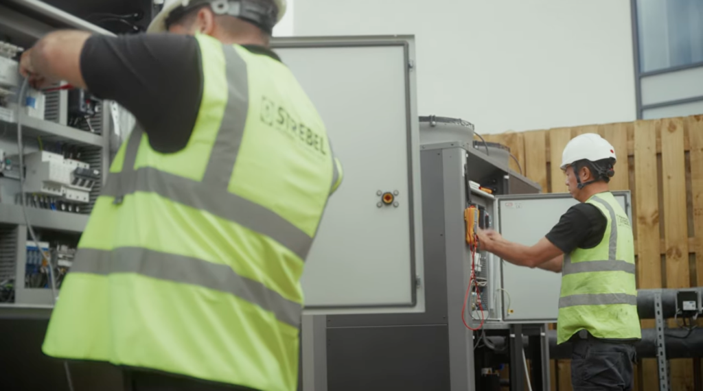 Strebel engineers actively commissioning the NTI-45 internal control panel.